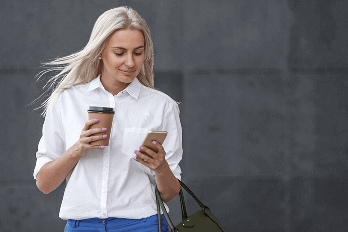 Nő nézi a telefonját.
