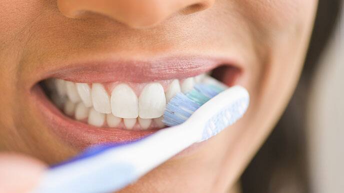 közelkép egy nő arcáról fogmosás közben